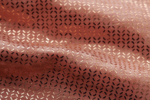 Golden clothing - naturally OEKO-TEX® certified Detail of a woven fabric with a golden textile finish from KURZ