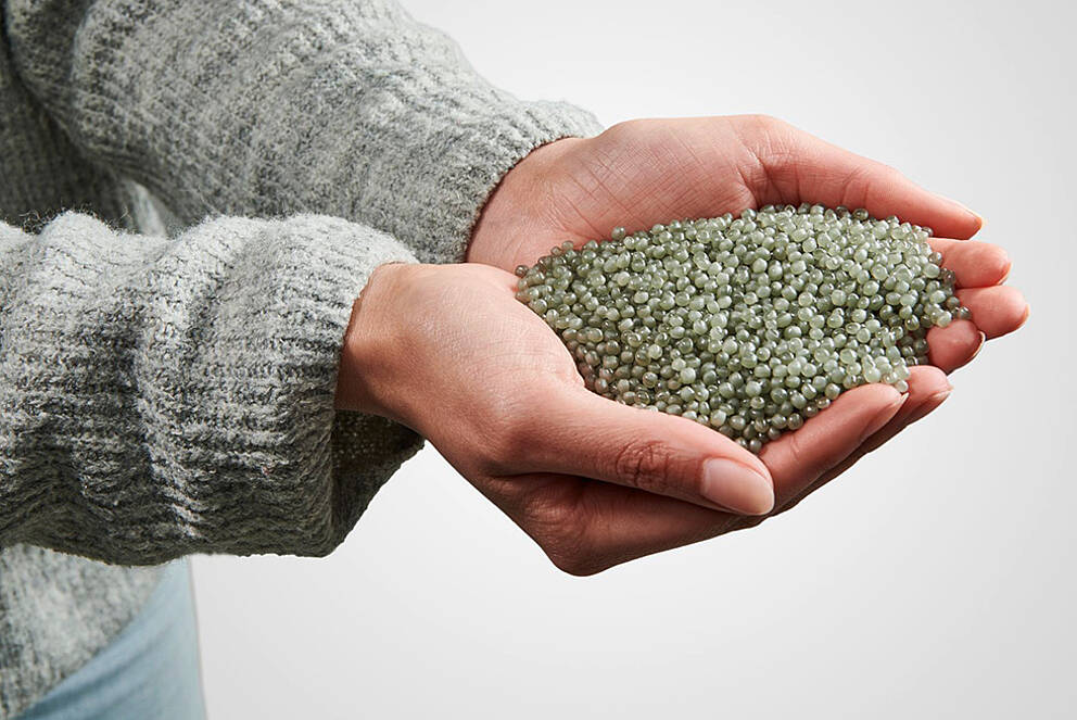 Reducing CO2 Footprint without Compromising on Packaging Design? Solutions for Eco-Packaging Hands presenting recycled plastic granules from KURZ embossed foils
